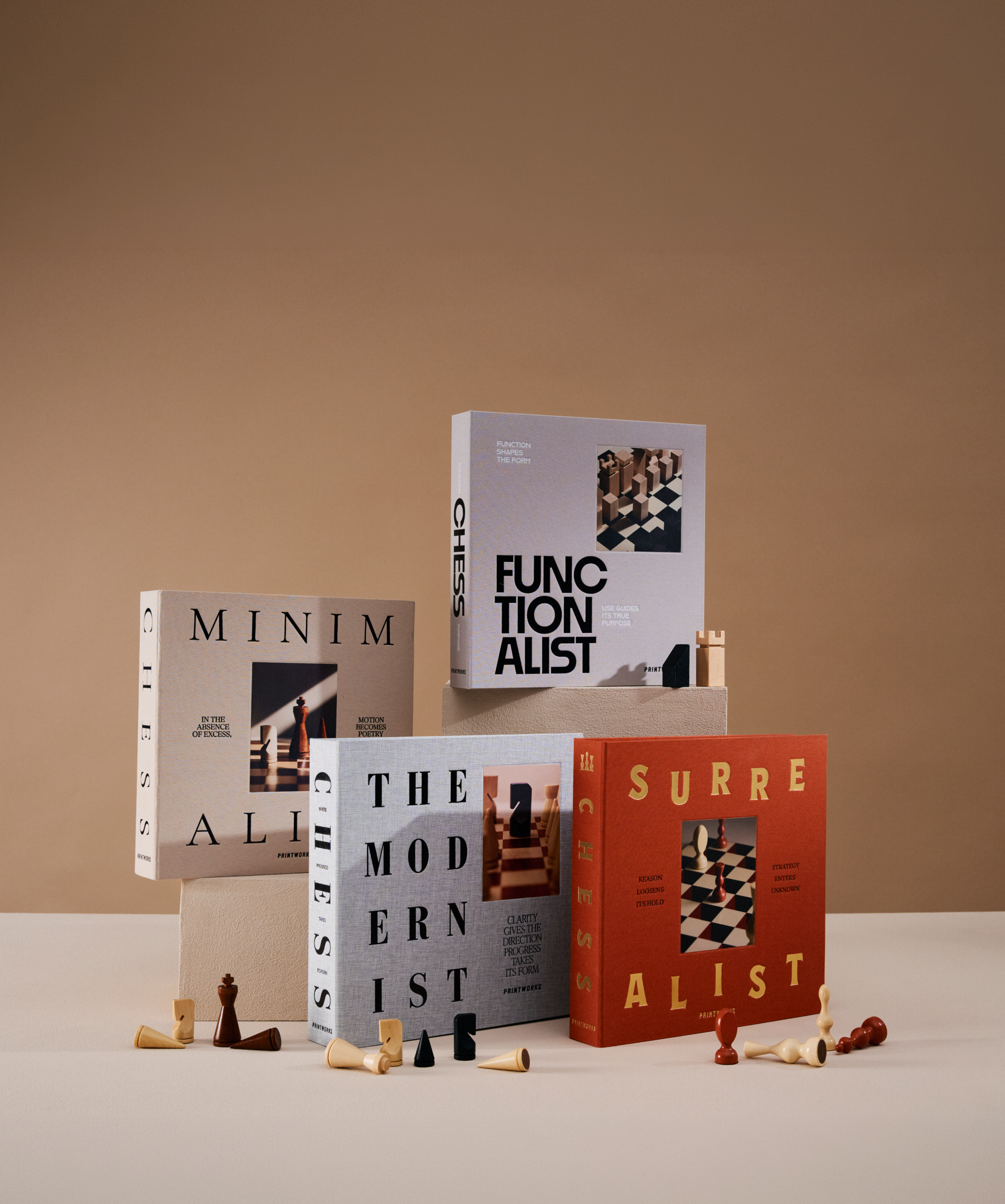 Printworks Chess sets Minimalist, Functionalist, The Modernist and Surrealist displayed with scattered wooden chess pieces